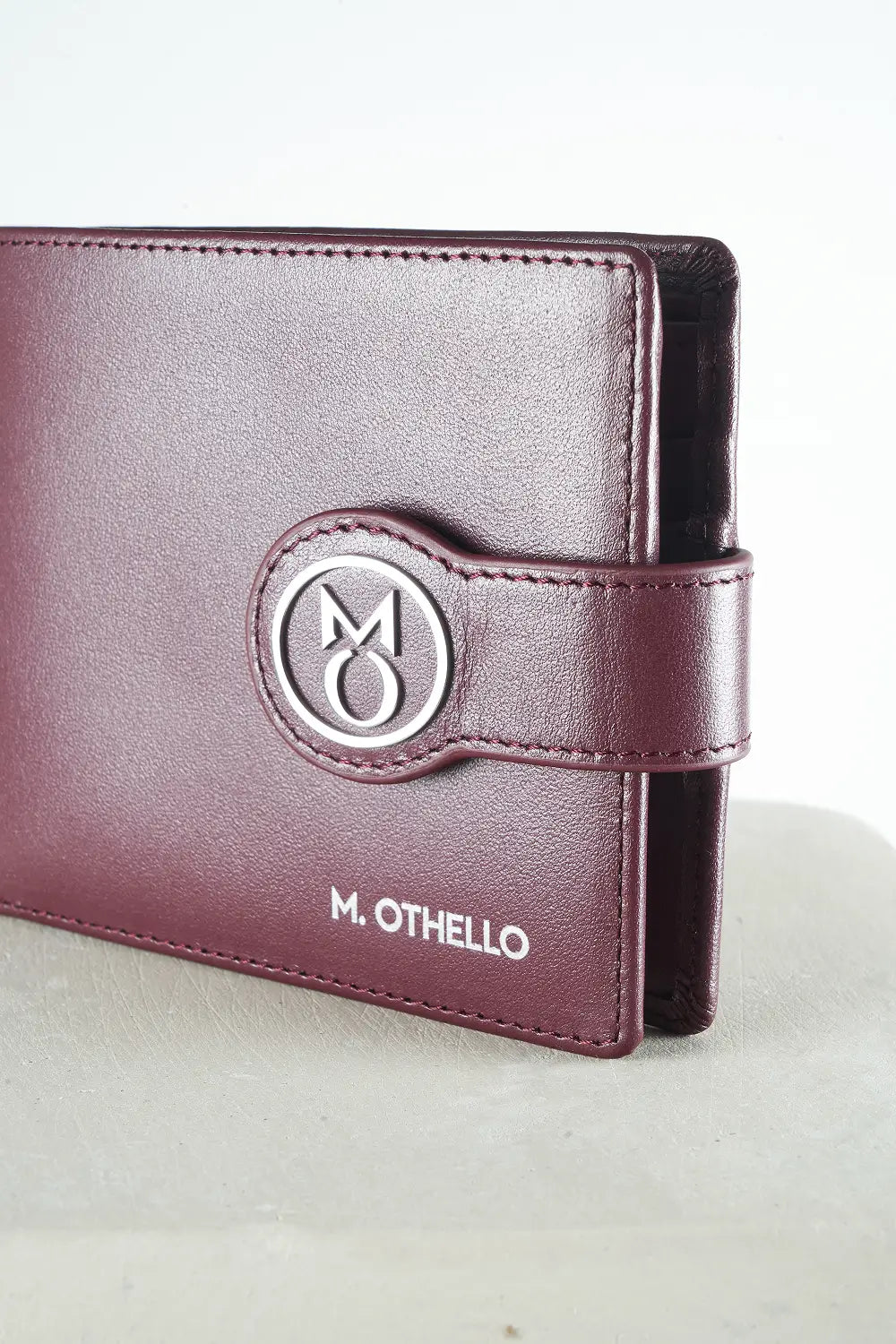 Burgundy bi-fold wallet with brand logo on a light background