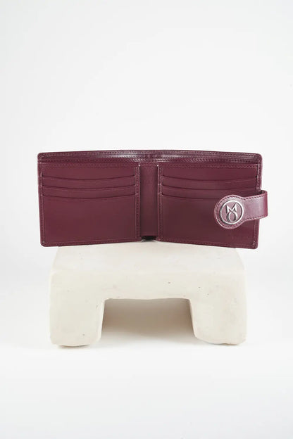 Burgundy bi-fold wallet with brand logo on a light background