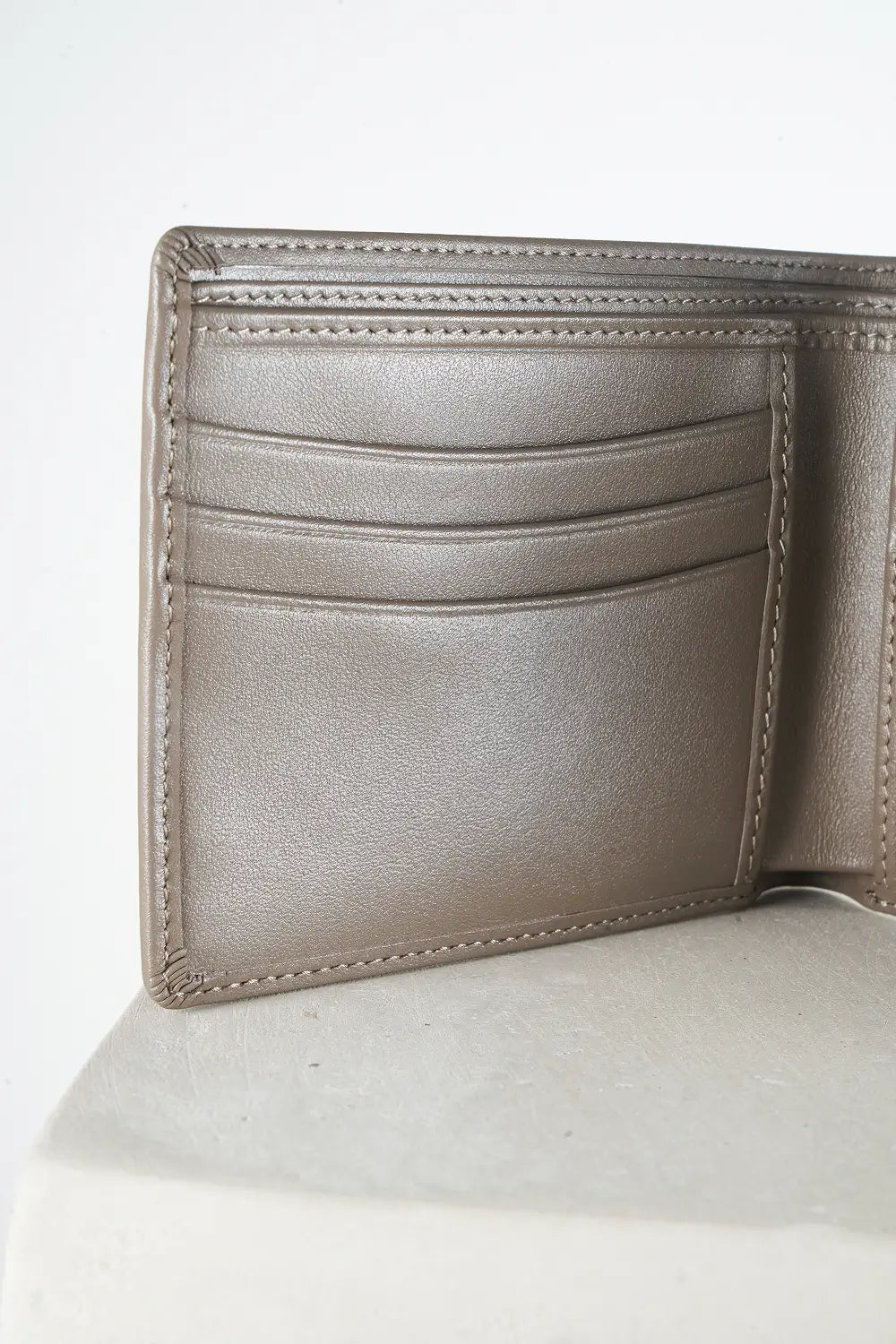 Gray bi-fold wallet with brand logo on a light background