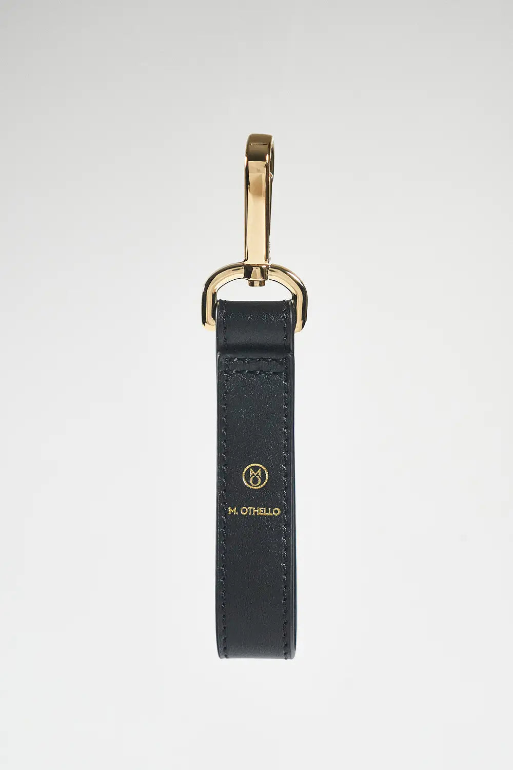 Black leather keychain with gold clasp on a white background
