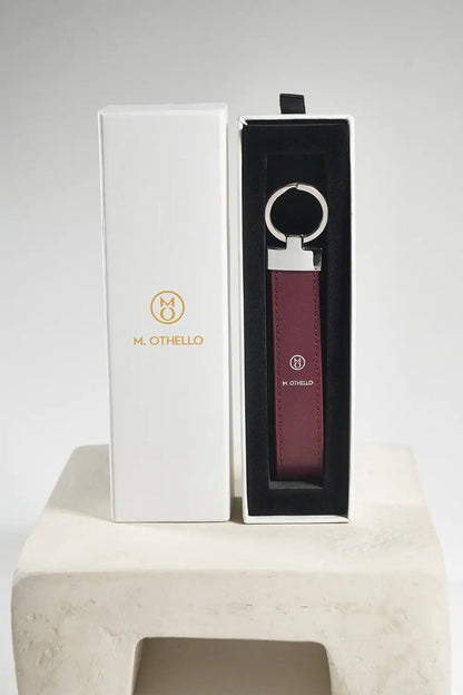 Burgundy keychain with silver ring on a light gray background