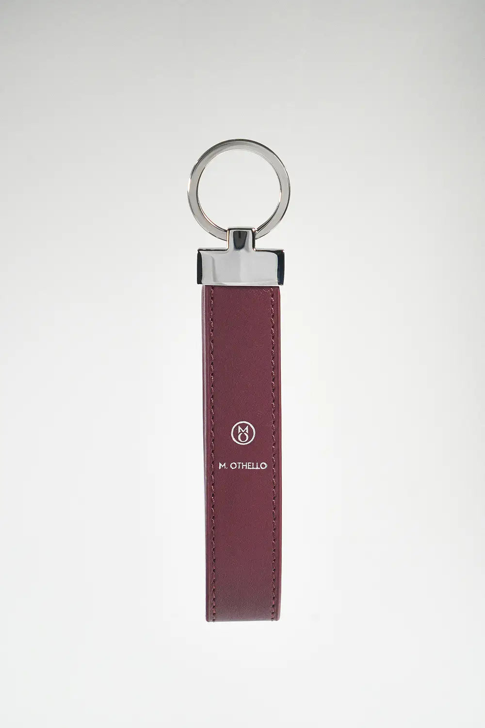 Burgundy keychain with silver ring on a light gray background