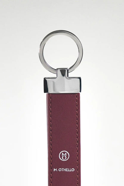 Burgundy keychain with silver ring on a light gray background