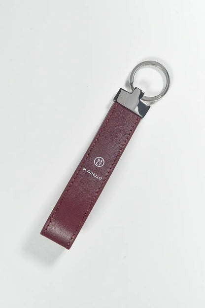 Burgundy keychain with silver ring on a light gray background