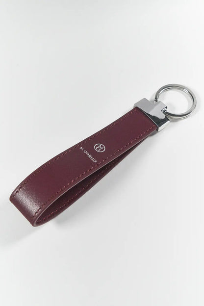Burgundy keychain with silver ring on a light gray background