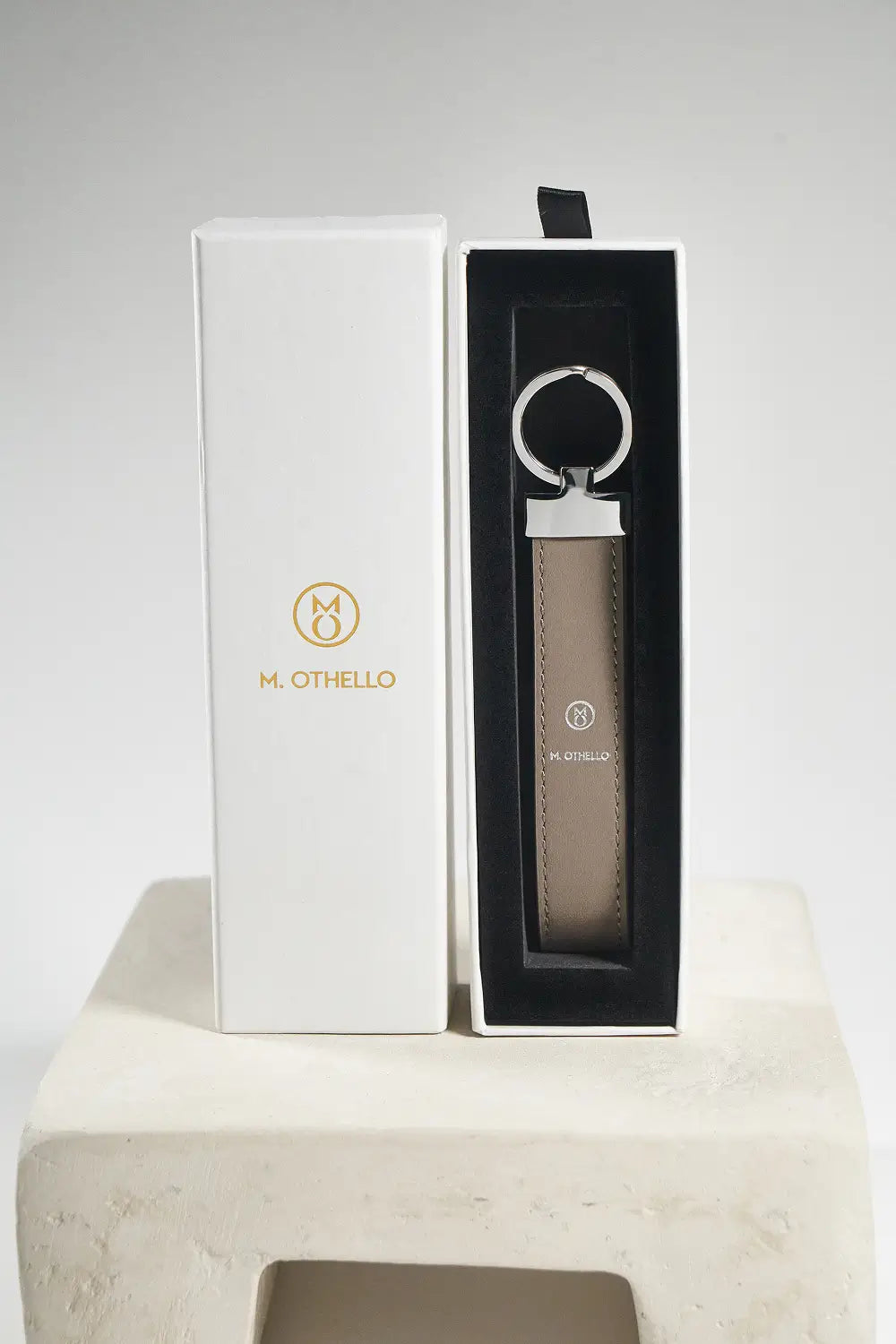 Gray keychain with silver ring on a light gray background