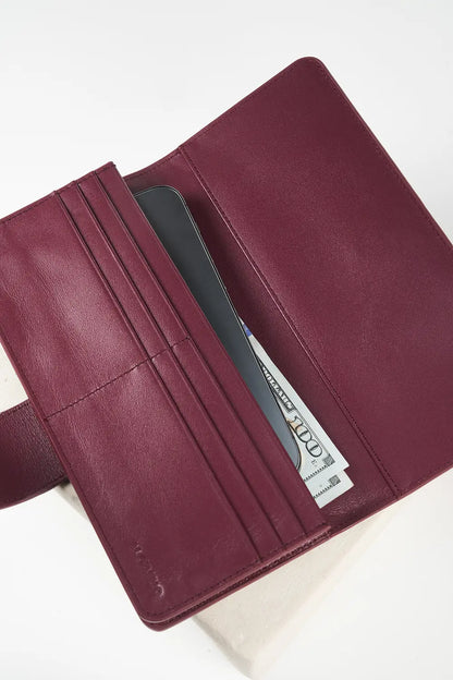 Burgundy leather wallet with 'M. Othello' branding on a light gray background.