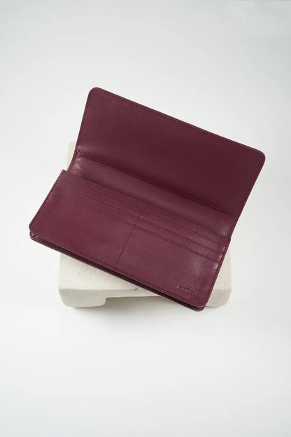 Burgundy leather phone wallet with 'M. Othello' branding on a light gray background.