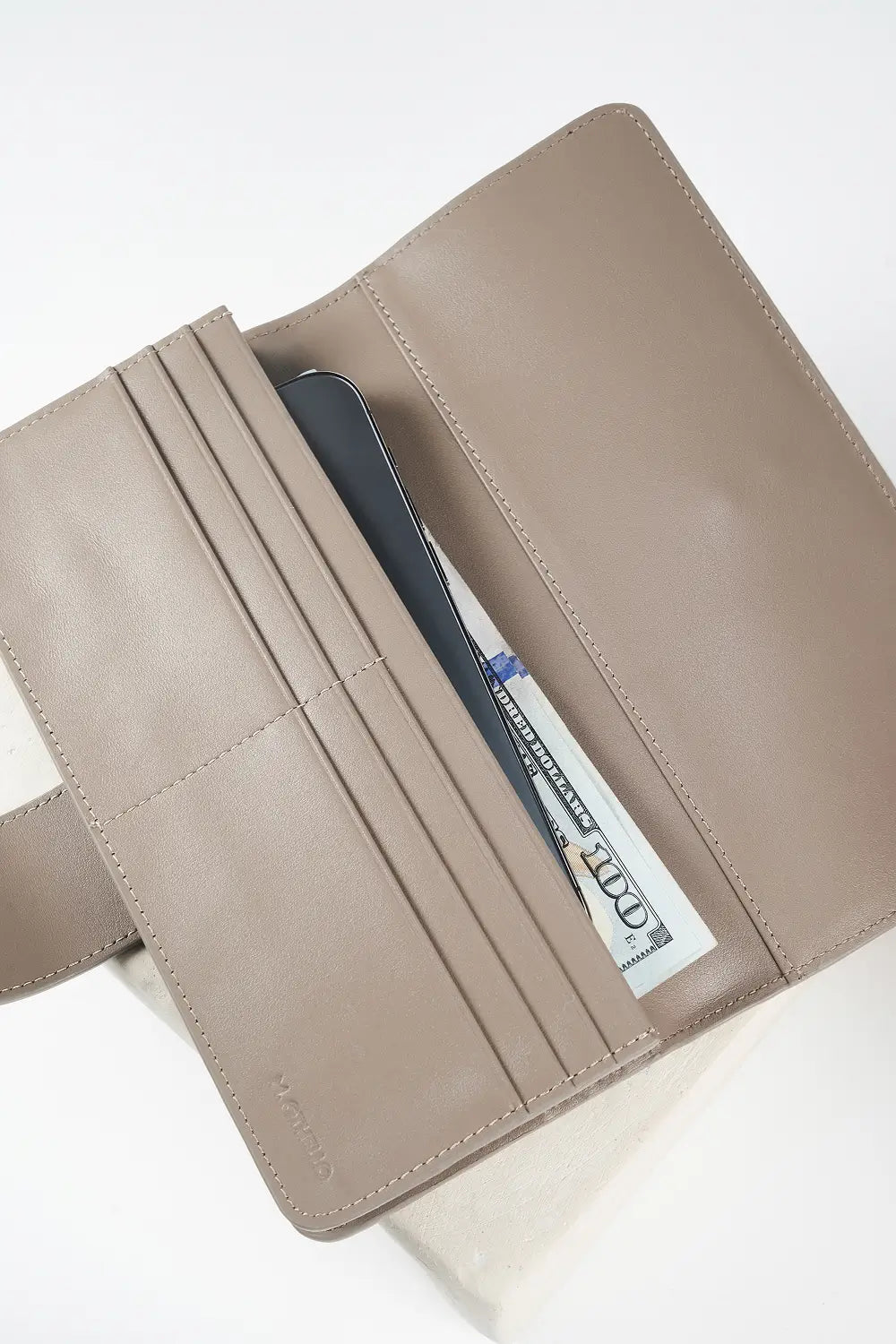 gray leather wallet with 'M. Othello' branding on a light background