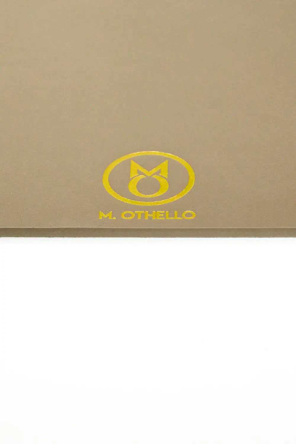 Gray leather mousepad with 'M. Othello' logo on a light background